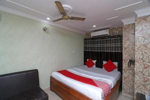 a bedroom with a bed with red pillows and a ceiling fan at OYO A G Residency & Son in Bumlitan