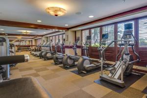 a gym with a row of treadmills and ellipticals at Ko Olina Beach Villas B506 in Kapolei