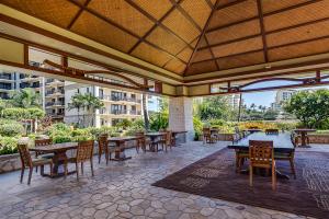 an outdoor patio with wooden tables and chairs at Ko Olina Beach Villas B506 in Kapolei +71 photos
