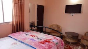 ein Schlafzimmer mit einem Bett mit einer rosa Decke in der Unterkunft Laskus , Darjeeling in Darjeeling