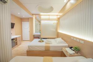 バンコクにあるThrive Hotelのベッド2台とキッチンが備わる小さな客室です。