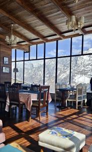 een eetkamer met uitzicht op een berg bij Faraway Cottages, Auli in Joshimath