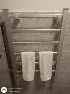 un portasciugamani con due asciugamani bianchi in bagno di Ripa Alta Room's a Cerignola