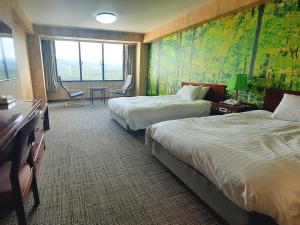大山的住宿－Mercure Tottori Daisen Resort & Spa，酒店客房带两张床和一张桌子以及椅子。