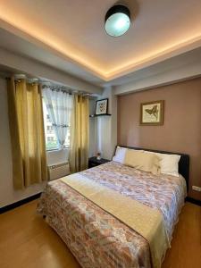 a bedroom with a large bed in front of a window at Homey & Stylish 2BR @ Burgos Circle, BGC, Taguig in Manila