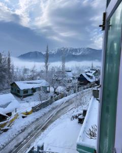 a view from a window of a snow covered street at Everest Guest House in Gulmarg