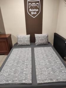 uma cama com duas almofadas num quarto em JOKER Party House - Sümeg em Sümeg