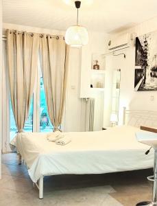 um quarto branco com uma cama e uma janela em Athens-acropolis apartment. em Atenas