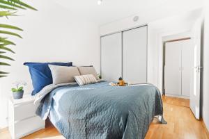 a bedroom with a bed with a blue blanket at Top floor with balcony - Super central - 5 pax in Oslo