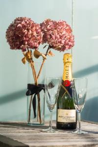 a bottle of wine and two glasses and flowers at Top floor with balcony - Super central - 5 pax in Oslo