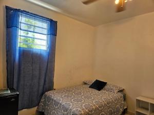 a bedroom with a bed and a window at Newly remodeled 2nd Floor Unit, 5 BR in Mayaguez