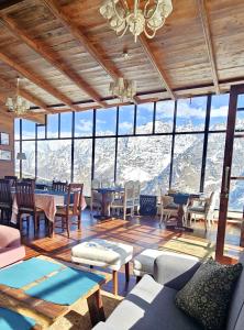 a living room with a view of the mountains at Faraway Cottages, Auli in Joshīmath