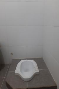 ein weißes WC auf einem Tisch in einem Zimmer in der Unterkunft SPOT ON 93612 Kencana Homestay Syariah in Mojokerto