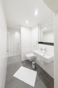 een witte badkamer met een wastafel en een toilet bij Landgasthaus Krimpenfort in Lohne