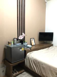 a bedroom with a bed and a desk with a television at nine guesthouse in Ban Pa Tung (7)