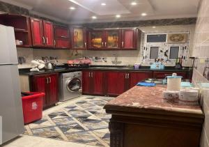 uma cozinha com armários vermelhos e uma bancada em Furnished apartment, great view, directly on the sea em Alexandria