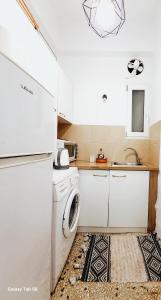 uma cozinha com um frigorífico branco e um lavatório em Athens center cozy apartment near acropolis em Atenas
