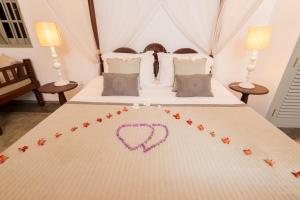 a bed with a heart drawn on it at The Horizon Hill Top Villa in Unawatuna