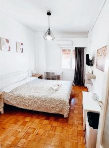 um quarto com uma cama e piso em madeira em Athens center cozy apartment near acropolis em Atenas