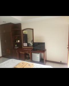 a bedroom with a bed and a desk with a mirror at EKALUK PLACE INN in Pattaya North +6 photos