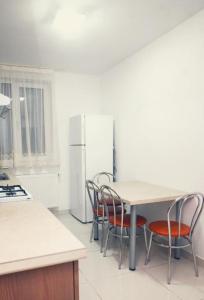 a kitchen with a table and chairs and a refrigerator at Robert's Apartment in Bistriţa