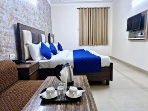 een hotelkamer met een bed met blauwe kussens bij Hotel Mayank Plaza-Near IGI Airport Terminal-3 in New Delhi