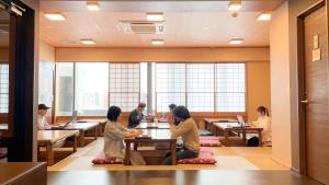 a group of people sitting at tables in a restaurant at COGO Ryogoku in Tokyo