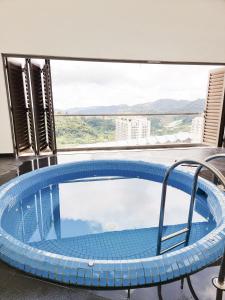 a large plunge pool in a room with a large window at Mossy Forest Family Retreat 2, Kea Farm Brinchang in Cameron Highlands