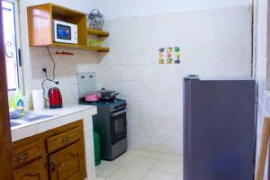 a small kitchen with a stove and a refrigerator at Résidence OSTHOME in Douala +2 photos