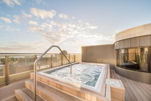 a hot tub on the balcony of a building at Oaks Sydney Hyde Park Suites in Sydney