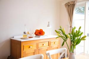 a kitchen with a wooden dresser and a table with chairs at Writer's Cottage, luxurious oasis in the heart of North Hobart in Hobart