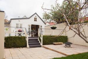 una casa blanca con una escalera delante en Writer's Cottage, luxurious oasis in the heart of North Hobart, en Hobart