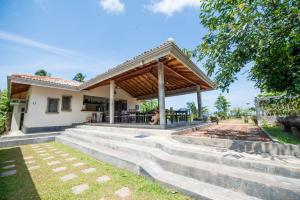 a home with a wooden pavilion on concrete steps at The Horizon Hill Top Villa in Unawatuna