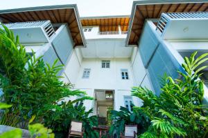 a view of a white building with trees at The Horizon Hill Top Villa in Unawatuna