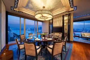 une salle à manger avec une table, des chaises et une grande fenêtre dans l'établissement The Azure Qiantang, a Luxury Collection Hotel, Hangzhou, à Hangzhou