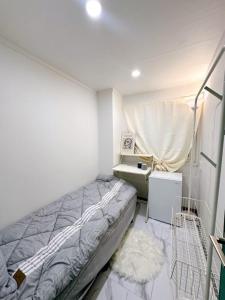 a small bedroom with a bed and a sink at Stay 2002 in Seoul