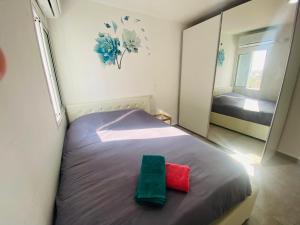een slaapkamer met een bed met twee handdoeken erop bij Beautiful apartment near Tel Aviv in Bat Yam
