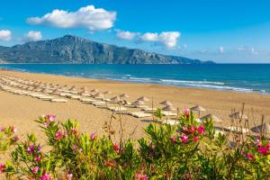 una playa con sillas y sombrillas y el océano en Villa Azalea 2, en Ortaca