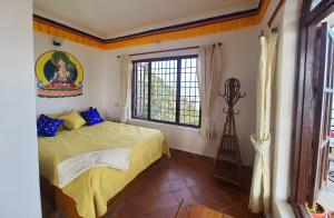 Schlafzimmer mit einem Bett und einem Fenster in der Unterkunft Peace Dragon Lodge in Pokhara