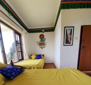 sypialnia z 2 łóżkami i oknem w obiekcie Peace Dragon Lodge w mieście Pokhara