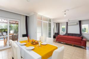 - une salle à manger avec une table et un canapé rouge dans l'établissement Villa Magnolia, à Dalyan