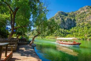 un bateau avec des gens dessus sur une rivière dans l'établissement Villa Magnolia, à Dalyan