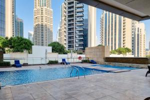 a swimming pool in a city with tall buildings at New Arabian - 8 Boulevard Walk Downtown Dubai in Dubai