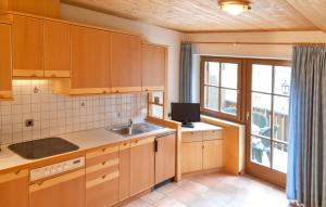 ラグンドにあるGarni Winklerhofのキッチン(木製キャビネット、シンク、窓付)
