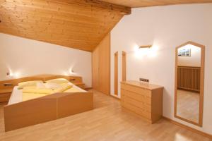 sypialnia z dużym łóżkiem i lustrem w obiekcie Garni Winklerhof w mieście Lagundo