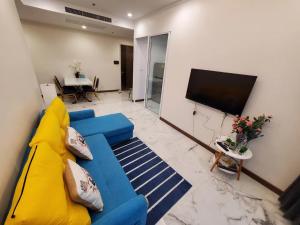 a living room with a blue couch and a tv at Supalai Bangkok in Bangkok