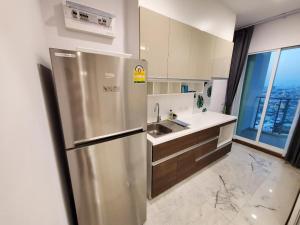 a stainless steel refrigerator in a kitchen with a window at Supalai Bangkok in Bangkok