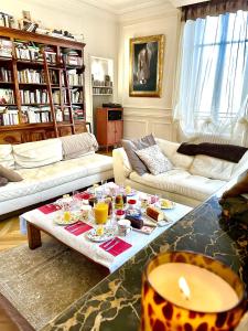una sala de estar con sofás y una mesa con comida. en Maunoury Citybreak, en Chartres