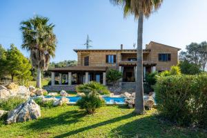 une maison avec une piscine et des palmiers dans l'établissement Can Bregat, à Alcúdia
