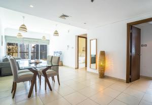 a dining room with a glass table and chairs at New Arabian - 8 Boulevard Walk Downtown Dubai in Dubai